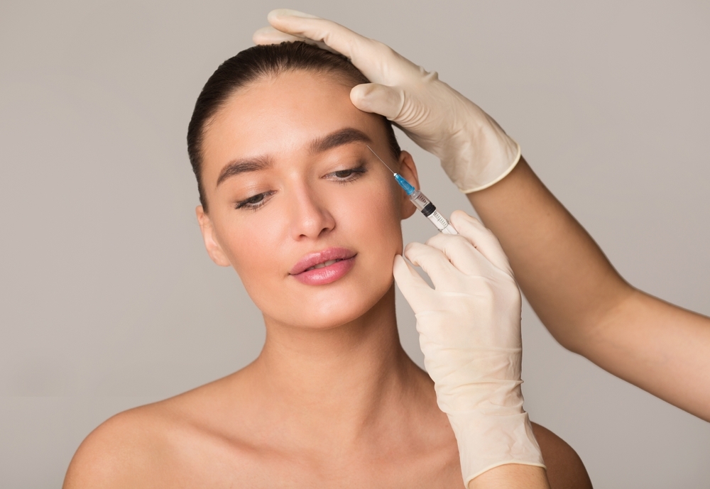Women having Botox injected under her eyebrows